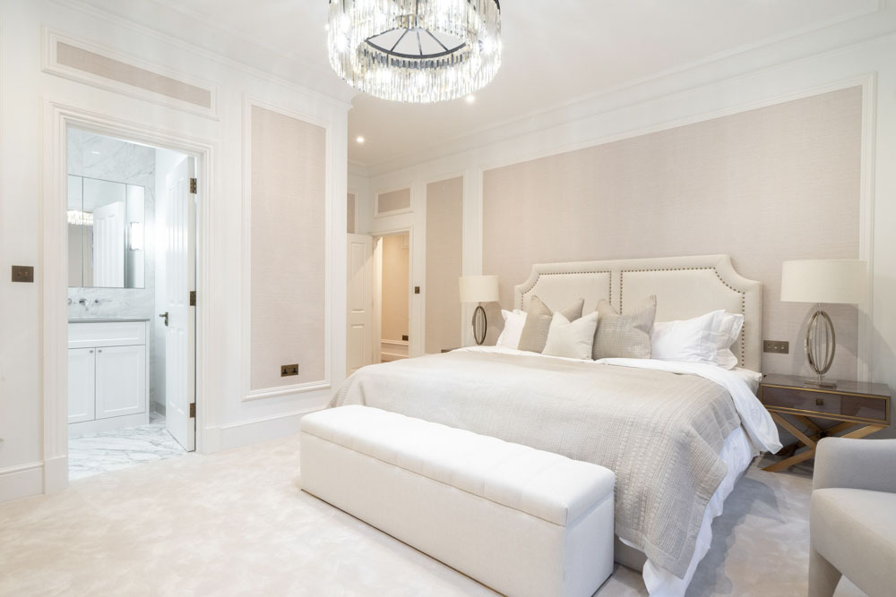 ft-architects-aldford-street-bedroom Cream principal bedroom by FT Architects with crystal chandelier, upholstered headboard and en suite beyond