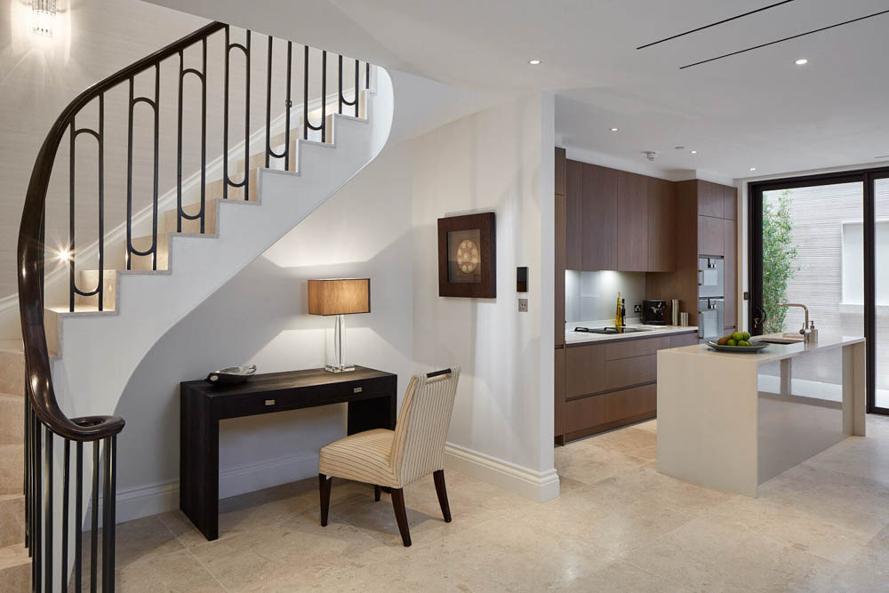 ft-architects-rex-place-kitchen Lower ground kitchen with walnut cabinetry and stone flooring beside the curved staircase and light well